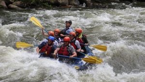 people in a raft going whitewater rafting